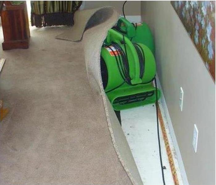 A drying machine being used to fix carpet after water damage